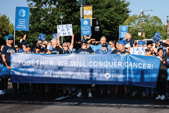 Citadel employees carrying the Together we will conquer cancer banner