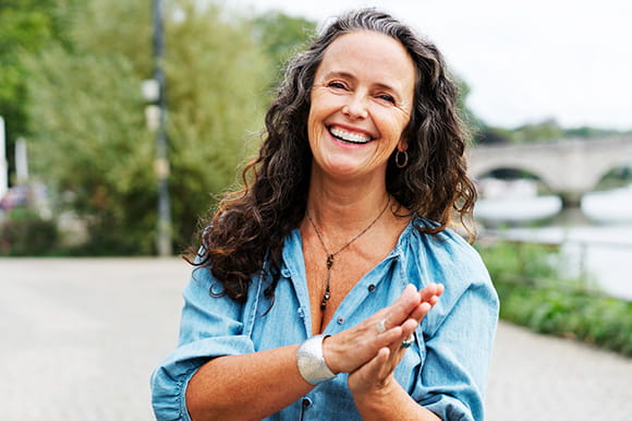 A Gen X woman smiling outside