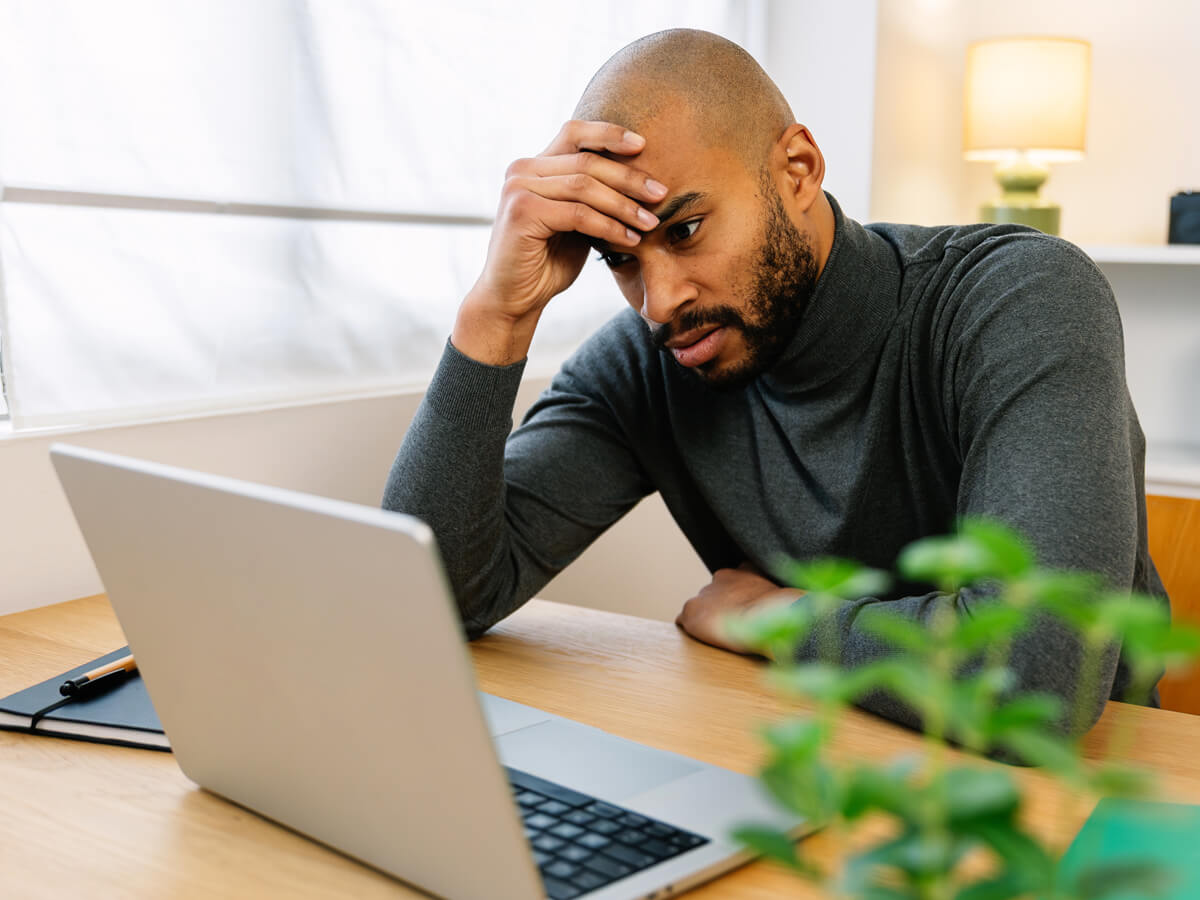 A man looking frustrated while on his computer