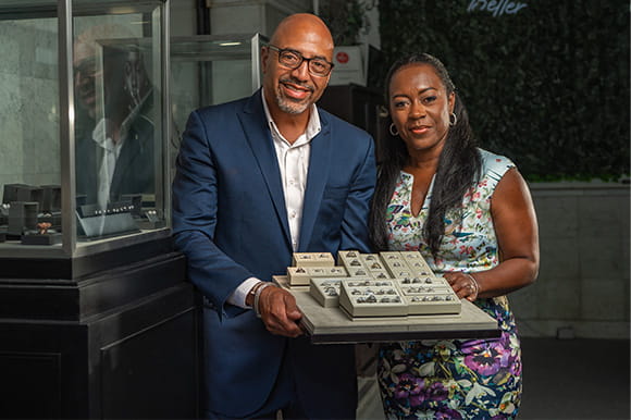 A man and a women holding jewelry in their store